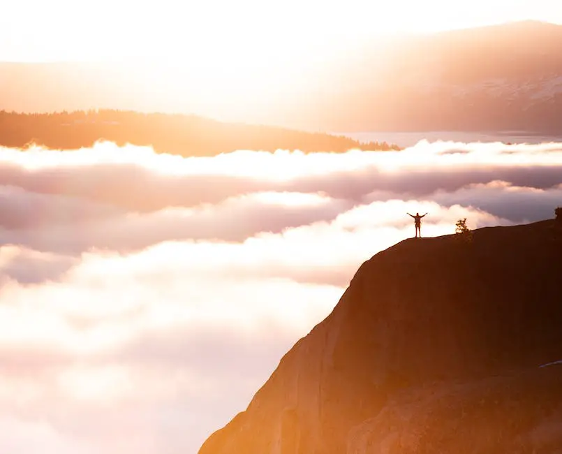 Image depicting the concept of motivation and inspiration, showing a person climbing a mountain with a sunrise in the background.